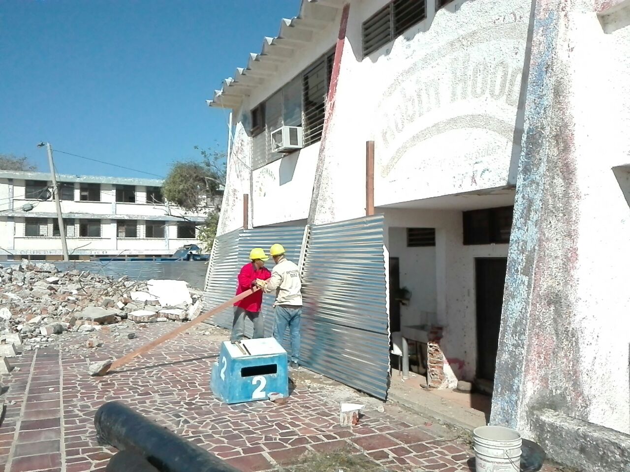 Operarios construyen el debido encerramiento de la obra con laminas de zinc y madera.