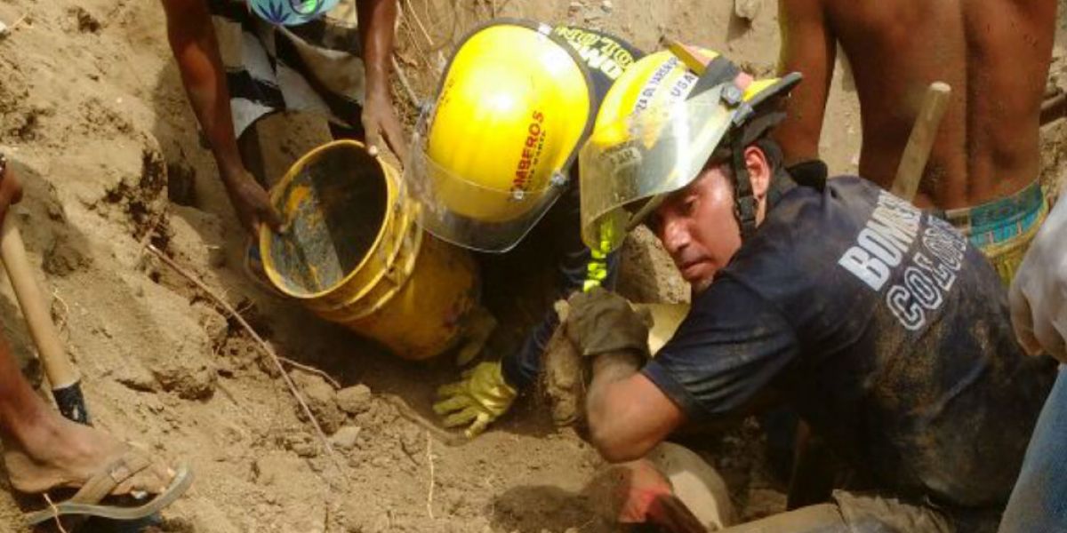 Bomberos Santa Marta Socorristas tratando de rescatar el cuerpo con la ayuda de la comunidad.