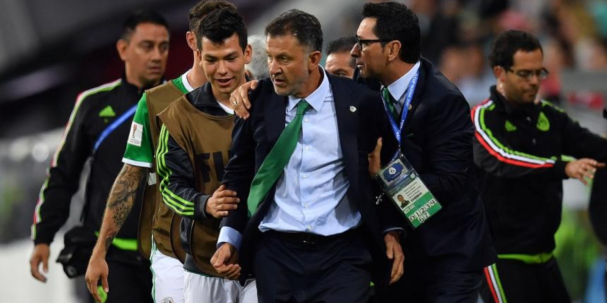 Foto: AFP. Osorio es sujetado por integrantes del cuerpo técnico y jugadores de la selección de México.