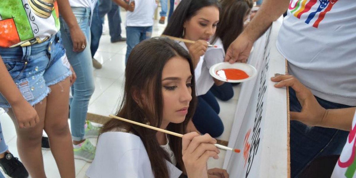 Las candidatas al XX Imperialato Nacional de La Cumbia dibujando la Bandera de la Paz.