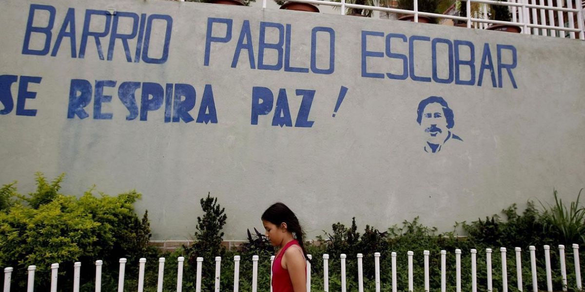  Una niña camina frente al mural que da la bienvenida al barrio Pablo Escobar en Medellín.