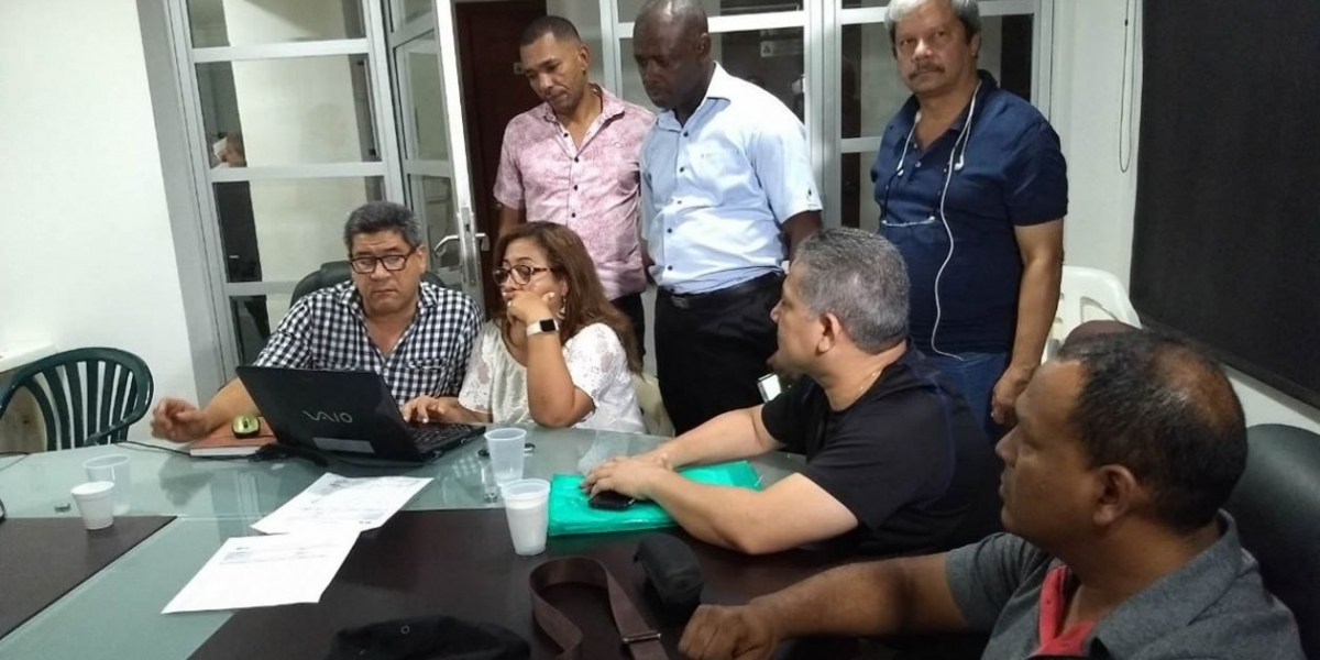 Trabajadores de la universidad firmando el acta.