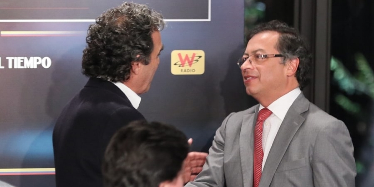 Sergio Fajardo y Gustavo Petro se dan la mano antes de participar en un debate.