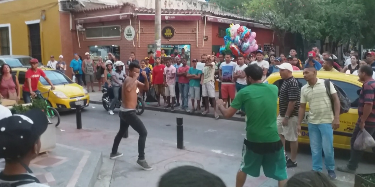 Momento en que una de las personas del establecimiento comercial peleaba con el hombre de la calle (de verde).