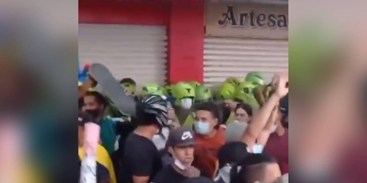 Momento en que los jóvenes protegen al grupo de policías.