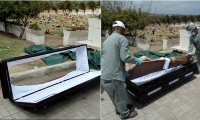 Trabajadores de la funeraria retiran el ataúd averiado.