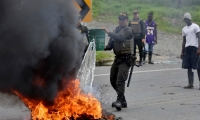 Miembros de la policía apagan una barricada en llamas durante una protesta el 3 de junio de 2017, en Buenaventura.