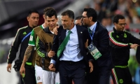 Osorio es sujetado por integrantes del cuerpo técnico y jugadores de la selección de México. 