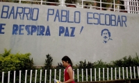  Una niña camina frente al mural que da la bienvenida al barrio Pablo Escobar en Medellín.