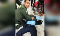 Momento en que patrullero y joven auxilian a vigilante atacado a bala.