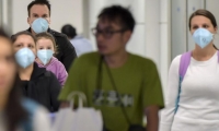 Personas caminan con tapabocas en el aeropuerto de Brasil. 