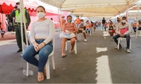 Personas en Makro esperando para redimir el bono solidario.