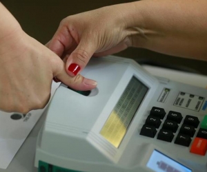 Una mujer registra su huella antes de votar hoy en la ciudad de Brasilia.