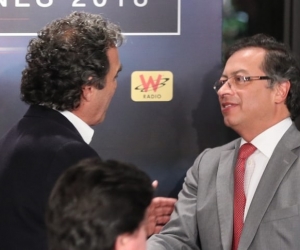 Sergio Fajardo y Gustavo Petro se dan la mano antes de participar en un debate.