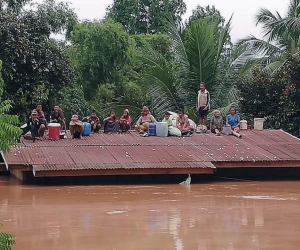 Un grupo de personas aguarda en lo alto de un tejado en una zona inundada tras el derrumbe de una presa hidroeléctrica en un pueblo cercano a la provincia de Attapeu, en Lao.