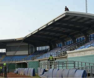 Hombre subido en el techo del estadio de beisbol.