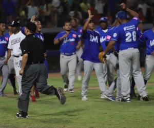 Vaqueros celebran tras que el umpire cantara el out 27 por interferencia de Erick Salcedo.