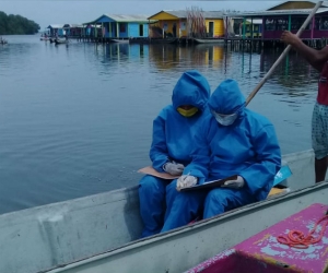  Los mensajeros pedagógicos van casa por casa a bordo de una canoa. 