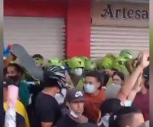 Momento en que los jóvenes protegen al grupo de policías.