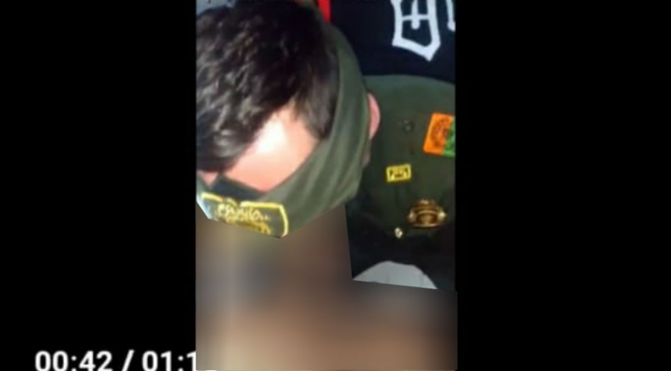 Captura del video en el que un hombre usa prendas de la Policía Nacional mientras tiene sexo oral.