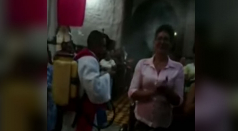 Captura de pantalla Noticias Caracol Sacerdote en Sabanalarga esparce agua bendita con fumigador