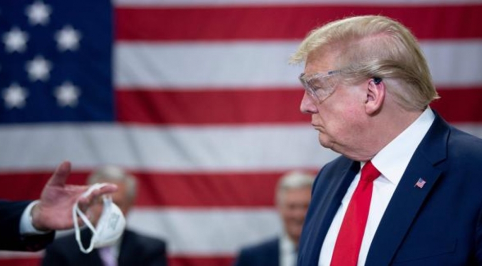 Donald Trump recibiendo una mascarilla.